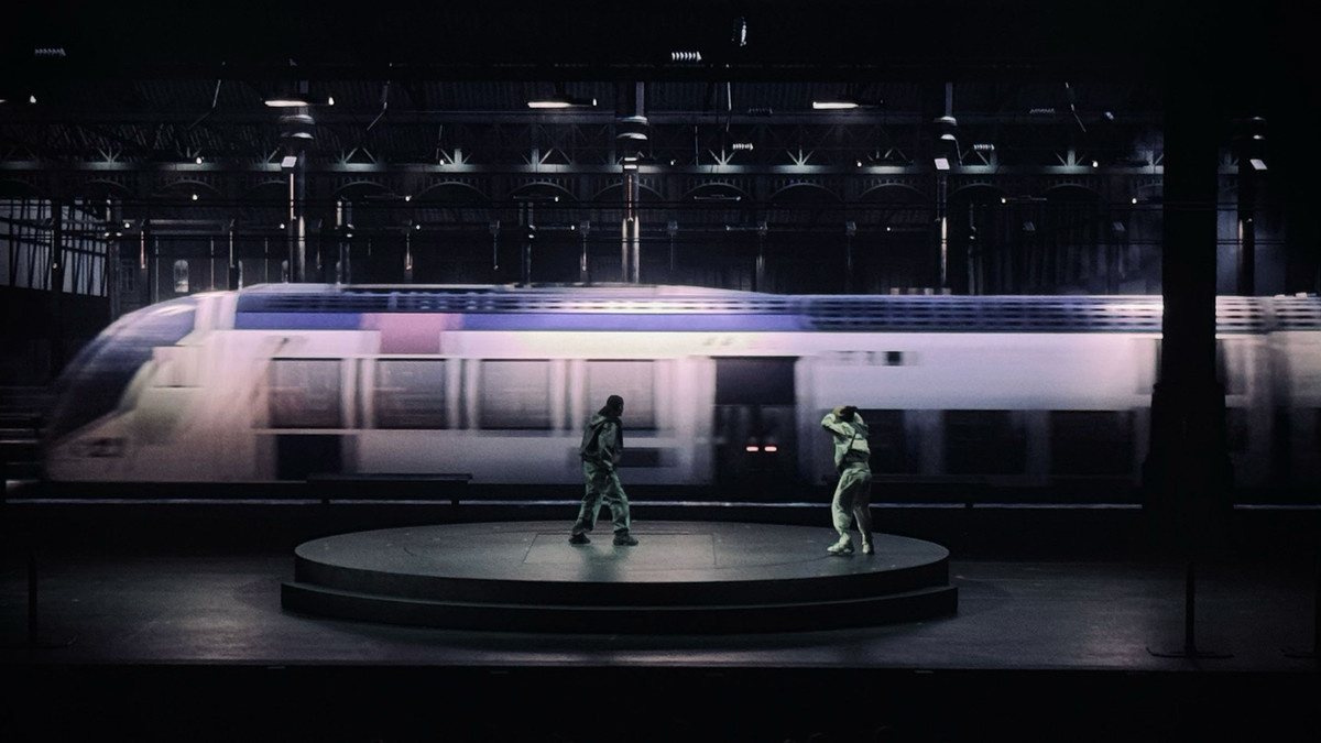 A train whizzes by on the LED screen of ‘La Haine: Jusqu’ici rien n’a changé’.