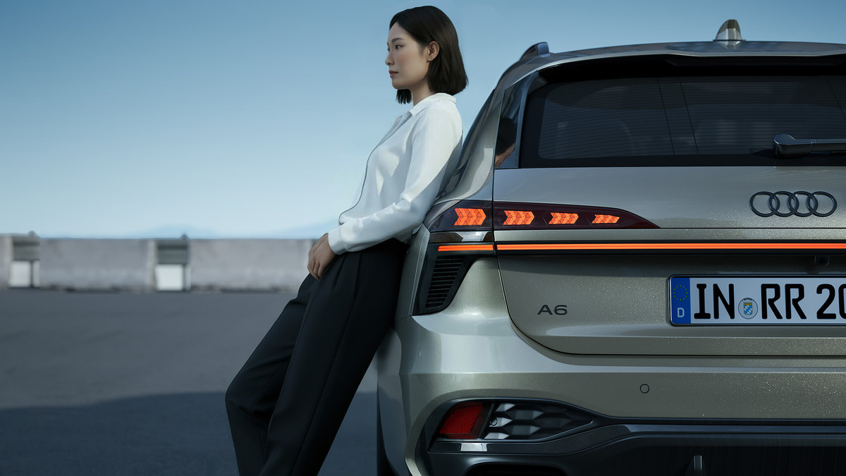 Audi 차량 문에 등을 기대고 서 있는 여성의 CG 렌더링