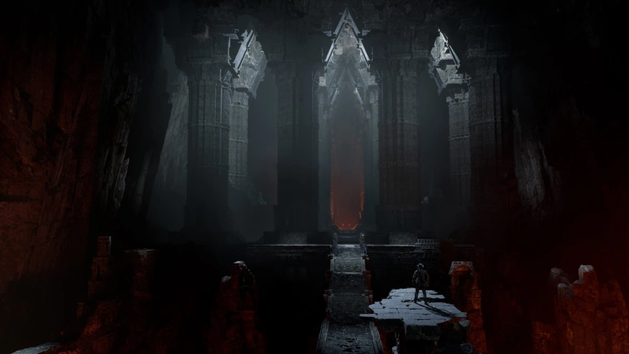 A man stands before large-scale, dark interior Mayan architecture.