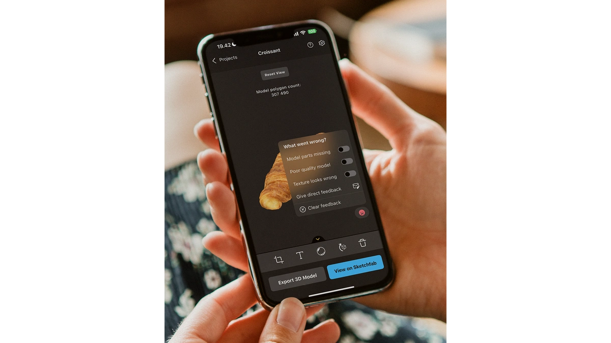 Hands holding a cell phone with a scanned image of bread and RealityScan user interface.